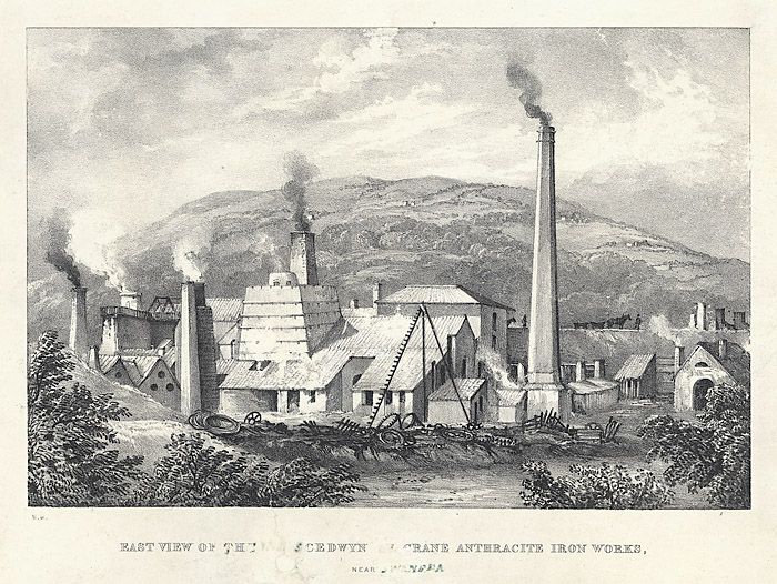 A nineteenth-century print of an ironworks in a valley, with smoking furnaces and hills behind.